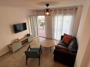 salon z kanapą, stołem i telewizorem w obiekcie Residence Turiga w mieście Estepona
