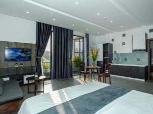 een hotelkamer met een bed, een keuken en een kamer bij Charm Champion Villa Hoian in Hội An