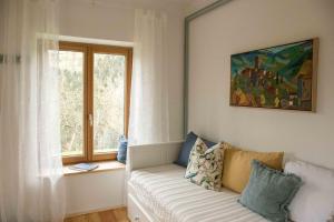a living room with a couch and a window at Blue in Green Apartment in Single Trail Park Jamnica in Prevalje