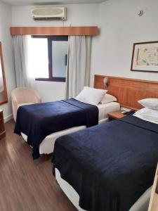 a hotel room with two beds and a window at Flat Space Valley - Para 2 Pessoas in São José dos Campos