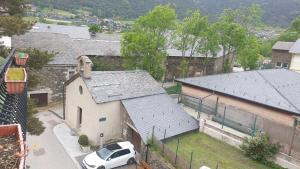 una macchina bianca parcheggiata di fronte a una chiesa di Residencia Aldosa a LʼAldosa