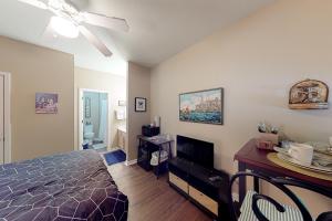 a bedroom with a bed and a desk and a television at Anchors Away in Sunset Beach