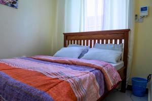 a bedroom with a bed with a blanket and a window at City Gem Near Tanzanite Bridge! in Dar es Salaam