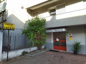un edificio con una puerta roja y un transmisor de hotel en Pensione Trento en Mestre