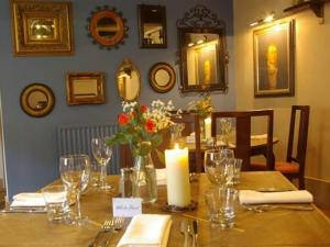 una mesa de madera con una vela y flores en White Hart Inn, en Ironbridge
