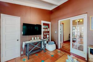 a living room with a tv and a table and a door at Historic on 5th in Tucson +20 photos