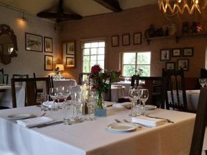 una sala da pranzo con tavolo e bicchieri da vino di White Hart Inn a Ironbridge
