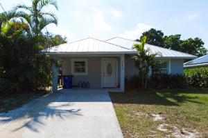 a small white house with a driveway at New Construction - Pristine Home - Great Location in Stuart