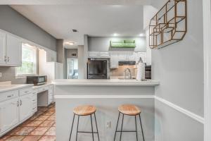 a kitchen with white cabinets and two stools at Cozy in Cordova-- Close to I-40 in Memphis