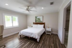 a bedroom with a bed and a ceiling fan at New Construction - Pristine Home - Great Location in Stuart
