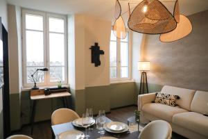 a living room with a couch and a cross on the wall at La Villa Ponsin in Cognac