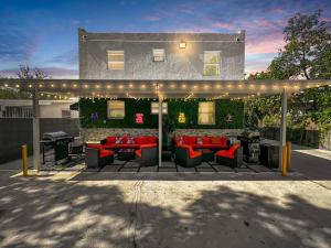 eine Terrasse mit Sofas, Tischen und einem Grill in der Unterkunft Vacay Spot Wynwood Comfort 2 Kitchen 2 BBQs Patio vibes, Prime LOC! 6 blocks away from Bars, Nite Clubs, Res, Shops in Miami