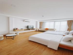 富國的住宿－Rosie Balcony Hotel Phu Quoc，白色卧室设有一张大床和一张沙发