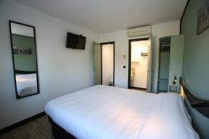 ein Schlafzimmer mit einem großen weißen Bett und zwei Spiegeln in der Unterkunft Enzo Hotels Chartres Mainvilliers by Kyriad Direct in Chartres