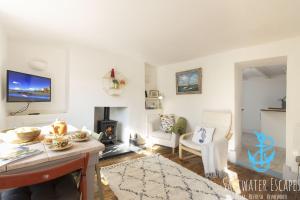 a living room with a table and a fireplace at Gerrys Cottage - Quaint Brixham Cottage with Log Burner in Brixham