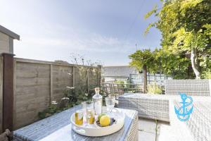 a tray of drinks and lemons on a table on a patio at Gerrys Cottage - Quaint Brixham Cottage with Log Burner in Brixham