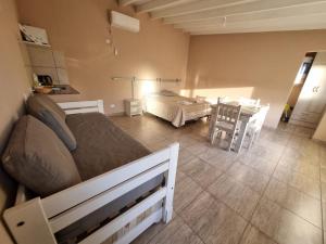 a bedroom with a bed and a dining room with a table at Las lupinas pleno centro in Coronel Suárez +8 photos