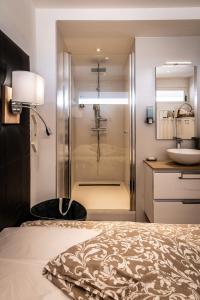 ein Badezimmer mit Dusche, Bett und Waschbecken in der Unterkunft Cap d'Agde Suit'Appart 42m2 T2 Village Naturiste in Cap d'Agde