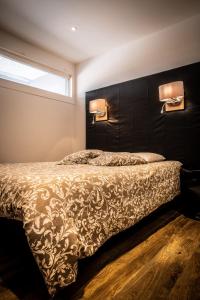 een slaapkamer met een bed en twee lampen aan de muur bij Cap d'Agde Suit'Appart 42m2 T2 Village Naturiste in Cap d'Agde