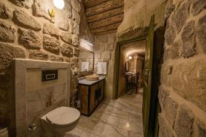 a stone bathroom with a toilet and a sink at Janus Cappadocia Hotel in Nevsehir