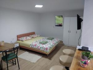 a small bedroom with a bed and a table and chairs at Apartmani Kuljanin in Donji Milanovac