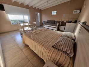 a bedroom with a bed and a living room at Las lupinas pleno centro in Coronel Suárez