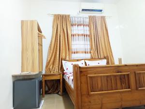 una camera con letto in legno e finestra di RÉSIDENCE NGUARY a Dakar