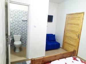 La salle de bains est pourvue de toilettes et d'un canapé bleu. dans l'établissement RÉSIDENCE NGUARY, à Dakar