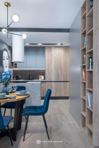 a kitchen and dining room with a table and blue chairs at City of the Kings - Podskale 18 in Krakow