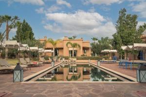 a resort with a pool in front of a building at Jnane Allia in Douar Soukkane