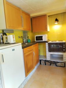 a kitchen with wooden cabinets and a white refrigerator at SeeYou Apartman Agárd in Agárd