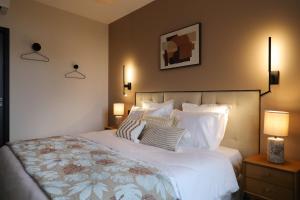 a bedroom with a large white bed with pillows at La Villa Ponsin in Cognac