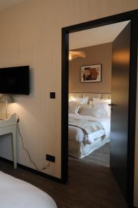 a mirror in a hotel room with a bed at La Villa Ponsin in Cognac