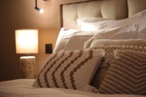 a bedroom with a bed with white pillows and a lamp at La Villa Ponsin in Cognac