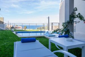 a patio with a table and chairs and a view of the ocean at Ilianthos in Panormos Rethymno