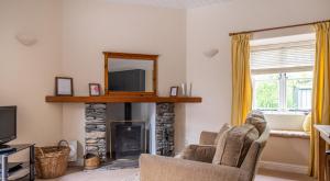 a living room with a fireplace and a mirror at Can Brow in Rusland