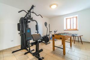 um quarto com um ginásio com uma bicicleta ergométrica e uma mesa em House nona Roza em Barban