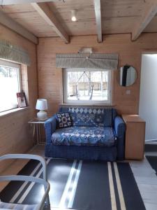 Karsin的住宿－Qubalonka Saunarium bis Bory Tucholskie，客厅设有蓝色的沙发和窗户。