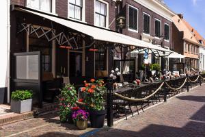 a restaurant with tables and flowers on a street at Boutique Hotel Elburg met Tapperij in Elburg