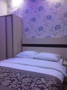 een slaapkamer met een bed met een paarse muur bij OTEL BURAK in Unye