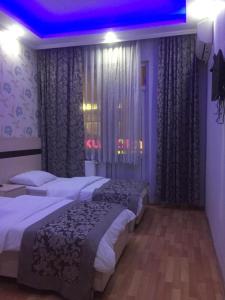 ein Hotelzimmer mit 2 Betten und einer violetten Decke in der Unterkunft OTEL BURAK in Unye