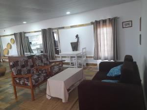 ein Wohnzimmer mit einem Sofa, Stühlen und einem Tisch in der Unterkunft Rwanda African Art Museum in Nyabisindu