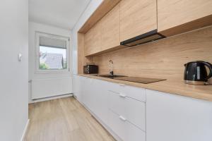 a kitchen with white cabinets and a window at Na Grobli Riverside Apartment & FREE GARAGE by Renters in Wrocław