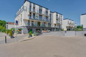 ein großes weißes Gebäude mit Balkon auf einer Straße in der Unterkunft Na Grobli Riverside Apartment & FREE GARAGE by Renters in Breslau