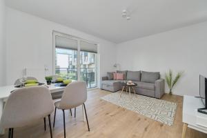 een woonkamer met een tafel en stoelen en een bank bij Na Grobli Riverside Apartment & FREE GARAGE by Renters in Wrocław