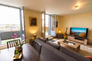 sala de estar con sofá y TV en Le Pont Royal en Amboise