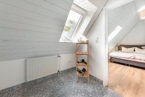 1 dormitorio en el ático con cama y ventana en Boutique 54° Nord en Büsum