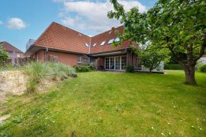 a house with a large yard in front of it at Boutique 54° Nord in Büsum