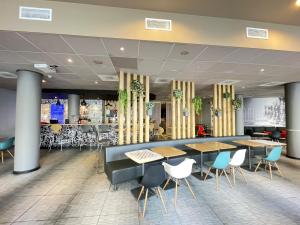 a dining area with tables and chairs in a restaurant at ibis Gent Centrum St. Baafs Kathedraal in Ghent