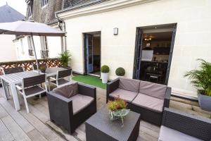 patio con tavolo, sedie e ombrellone di Le Pont Royal a Amboise
